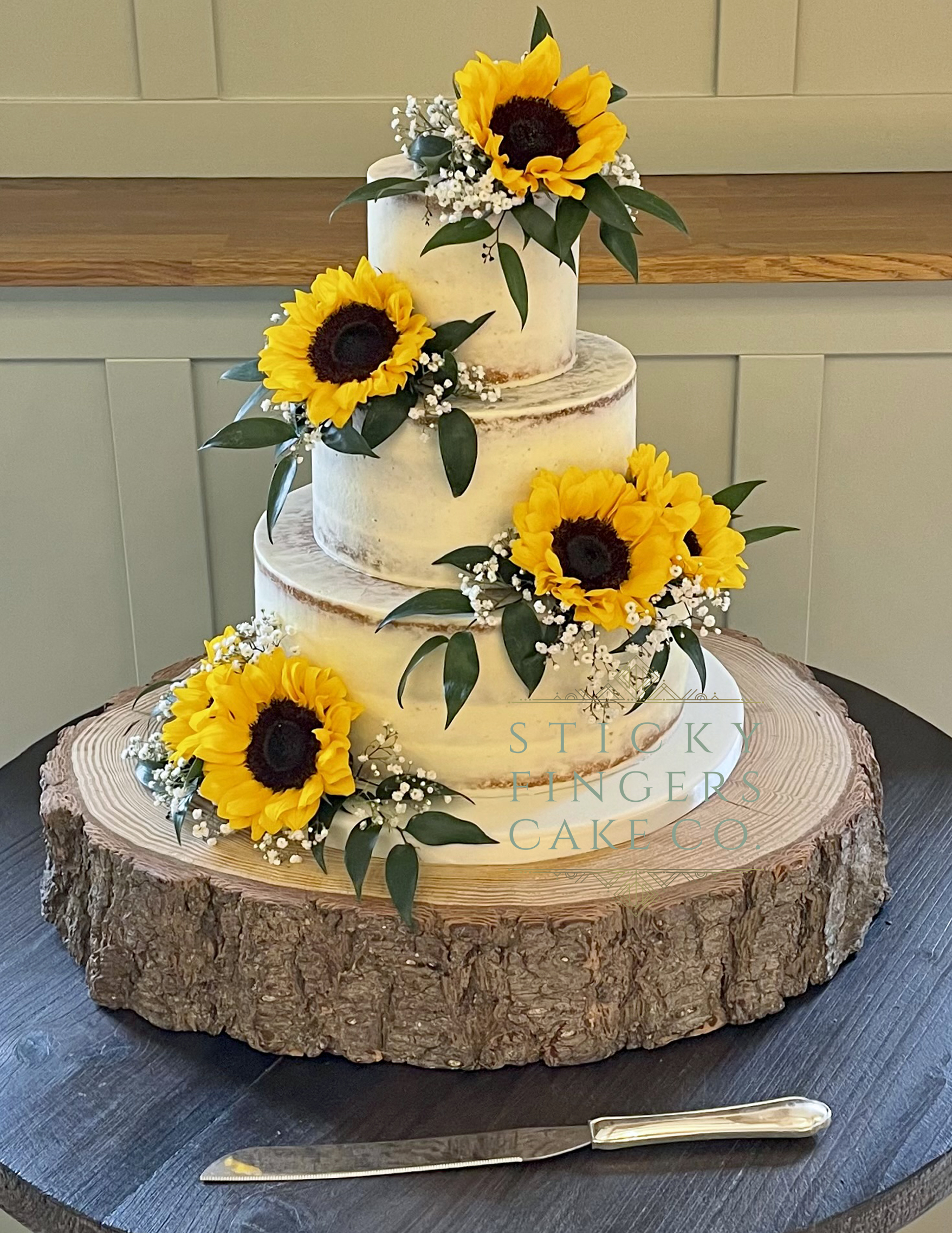 3-tier Semi Naked Wedding Cake with sunflowers displayed at Apton Hall, Rochford